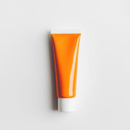 A visually striking orange tube with a glossy finish, perfect for showcasing skincare or cosmetic products on a clean backdrop, enhancing promotional displays.の素材