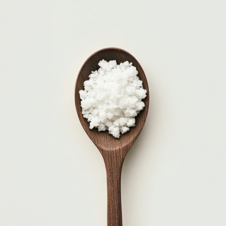 A detailed close-up of coarse sea salt resting on a wooden spoon, showcasing its texture and purity. Ideal for culinary, healthy lifestyle, and food photography themes.の素材