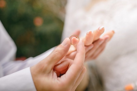 wedding day, the groom dresses the ring on the finger of the brideの写真素材