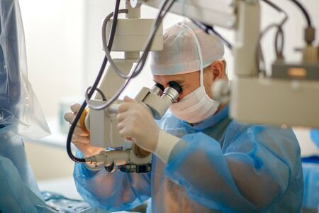The doctor looks through a microscope, the aphtholmologist performs an operation on the eyes, a...