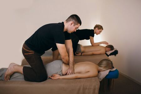 A man and a woman relax in the spa salon, professional massage therapists do a massage, the guy and the girl enjoyの写真素材