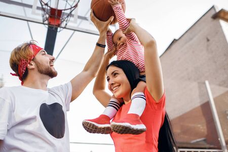 sports family plays basketball, mom, dad and daughter
