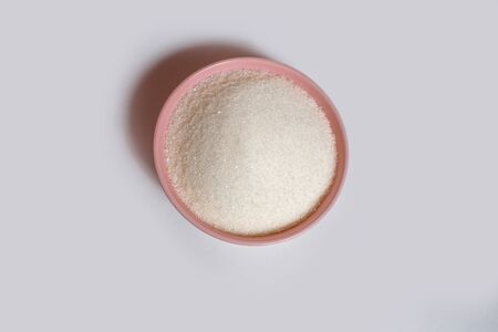 pink plate filled with sugar on a white backgroundの写真素材