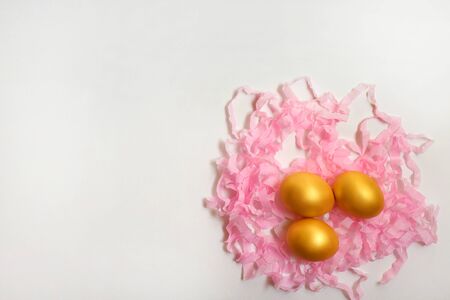 Golden quail eggs on a serpentine on a white background, free space for text or advertising