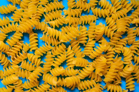 Fusilli spiral paste on a blue background, top viewの写真素材