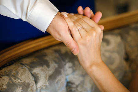 hand of the bride and groom close-up, wedding rings, horizontal photoの写真素材