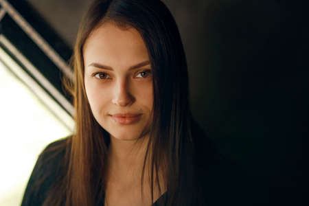 Portrait of a young girl in a dark interiorの写真素材