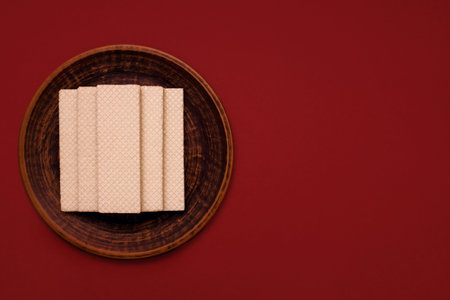 Wafer cookies in a ceramic plate on a red background top viewの写真素材