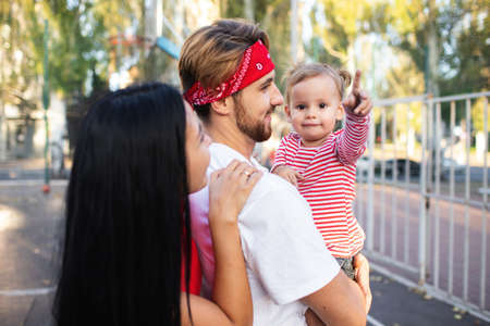 Dad, mom and daughter walk in the fresh air in the eveningの写真素材