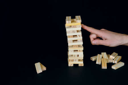 Wooden board game on a black background. People play a game of chance in which balance is important....