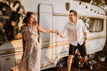 Young man and woman having fun outside their mobile homeの写真素材