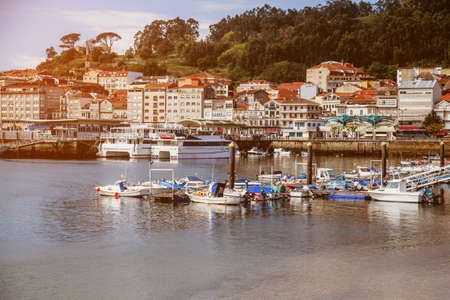Beautiful coastline with boats and yachts in the resort town. Ancient houses near the coast on the background of the sunset. Beautiful landscape of a seaside townの写真素材