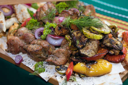 grilled meat cooked with grilled vegetables and laid out on a board. Restaurant dish ready to eat....