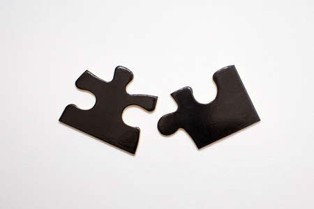 Two black puzzles on a white background. Puzzle for the development of children's intelligence. The concept of connection in the form of two plates of one whole. association and connection symbolの写真素材