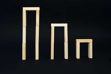 Wooden boards in the form of vertical frames on a black background. Three wooden frames from highest...