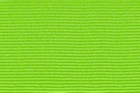 Background of a green washcloth for washing dishes. A green washcloth with uneven horizontal lines....