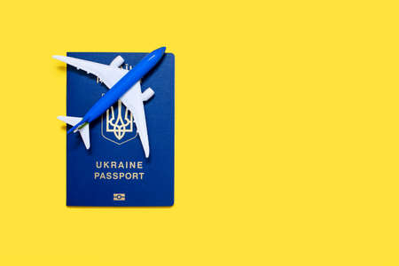 Biometric passport of a citizen of Ukraine with an airplane on a yellow background. International...