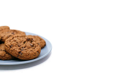 Chocolate chip cookies lie on a plate on a white background with free space for text. Sweet homemade chocolate chip cookies. American style breakfast with chocolate chip cookiesの写真素材