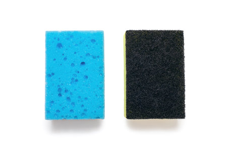 A blue washcloth and a rough-surfaced washcloth on a white background in the center of the image. Tool for washing dishes and cleaning the house. The concept of cleanliness and orderの写真素材