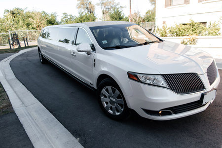 A long luxury white car is parked outside the hotel. Limousine in anticipation of VIP persons. beautiful white car close upの写真素材