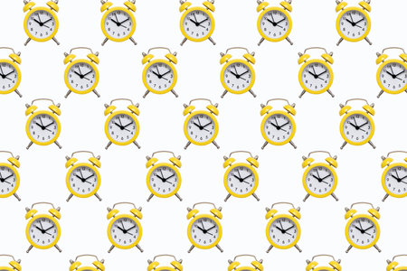 Pattern from yellow alarm clocks on a white isolated background. The background of many small alarm clocks in the form of a pattern. The concept of punctuality in the form of bright alarm clocksの写真素材