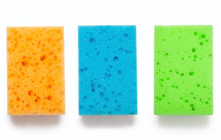 Three kitchen washcloths of different colors on a white isolated background. Orange blue and green washcloths. The concept of house cleaning and cleanliness of dishes. Everyday dishwashing toolの写真素材