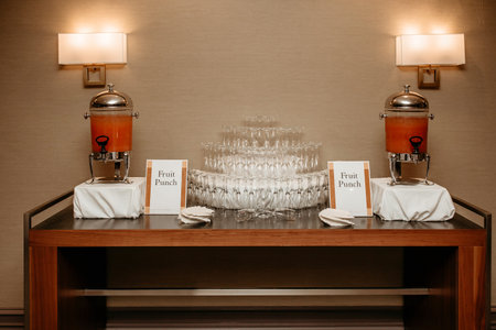 Table with fruit punch and empty glasses in a restaurant. Beautifully lined empty glasses in the shape of a pyramid. Preparing to receive guests at a party. Delicious fruit punch on the tableの写真素材