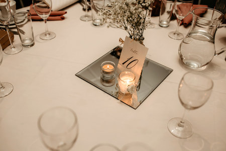 The table at restaurant number ten is decorated with flowers and candles. A beautiful table with a...
