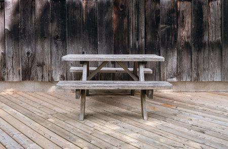 Old wooden bench and table on the background of wooden boards. wood products. Rural background and seating area in the form of a bench and a table. old weathered woodの写真素材