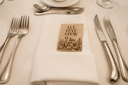 Cutlery in the form of knives and forks on a table in a restaurant and the inscription let's grow love. A text was written with a call to cultivate love. wedding party in a restaurantの写真素材