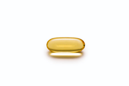 Fish oil capsule close-up on a white background. Fish oil is a healthy food supplement with vitamin D D3 and E. The concept of a healthy lifestyle and taking care of your own healthの写真素材