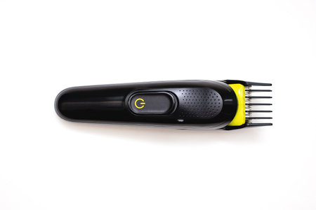 Razor trimmer for cutting hair lies on a white background. Electric shaver for barbershop. Accessory for shaving a beard or hair on a person's head. A tool to style your hair and beard from aboveの写真素材