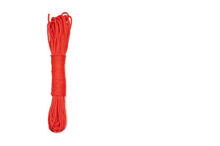 Bundle of neatly twisted red nylon rope on a white background. Red rope on a white background. Tool for economic activities in the form of a red rope. Free space for textの写真素材