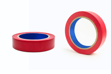 Two skeins of red electrical tape on a white background. A working tool in the form of an adhesive rubber tape for insulating electrical wiring. Red electrical tape on a white isolated backgroundの写真素材