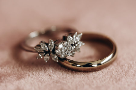 Wedding rings of the bride and groom with precious stones close-up. Wedding accessory in the form of gold rings with diamonds. Chic jewelry made of precious metals and stones in the form of ringsの写真素材