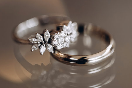 Wedding rings of the bride and groom with precious stones close-up. Wedding accessory in the form of gold rings with diamonds. Jewelry made of gold and precious stones in the form of wedding ringsの写真素材