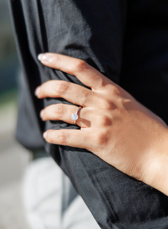 Hands of husband and wife couple on outside close-up. Woman's hand with wedding ring holding man's hand cropped photo. A man and a woman couple as a symbol of love, relationship, support and unityの写真素材