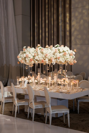 Table setting for a festive dinner or wedding in a restaurant. Luxurious table setting at a festive event with flowers and candles. A romantic setting in a restaurant or an elegant place with cutleryの写真素材