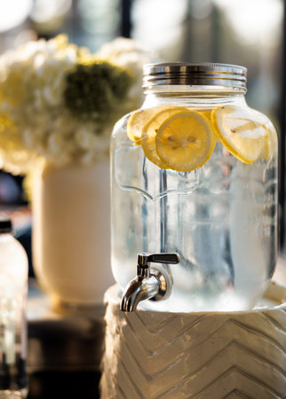 Cool and refreshing lemonade in a jug close-up. Water with fresh lemon slices for thirst quenching...