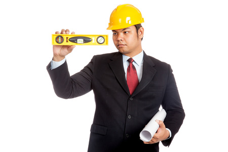Asian businessman hold a spirit level wear a hard hatの写真素材