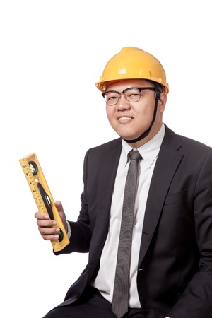 Asian businessman holding a spirit level and smile isolated on white backgroundの写真素材