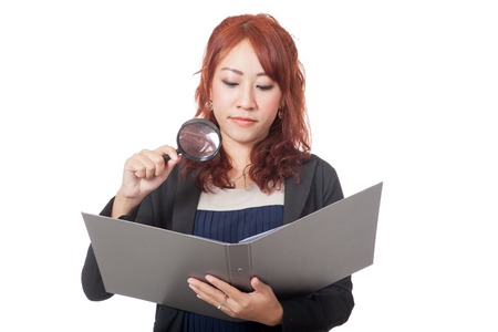 Asian office girl use magnifying glass check on a folder with bad mood isolated on white backgroundの写真素材