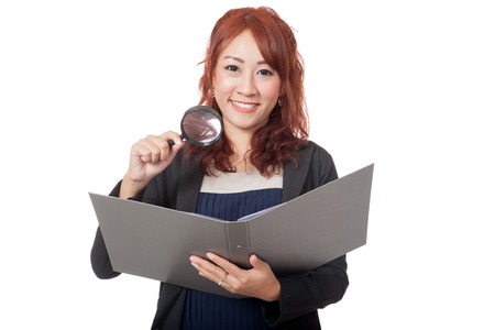 Asian office girl use magnifying glass check on a folder and smile isolated on white backgroundの写真素材