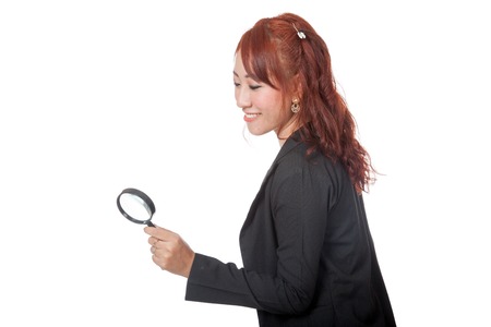 Asian office girl use magnifying glass looking down isolated on whtie backgroundの写真素材