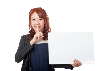 Asian office girl showing hand silence sign with a blank sign isolated on white backgroundの写真素材