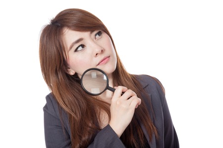 Asian businesswoman is  thinking with magnifying glass looking up isloate on white backgroundの写真素材