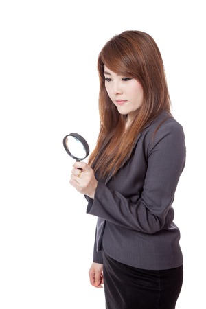 Asian businesswoman use magnifying glass looking down isloated on white backgroundの写真素材