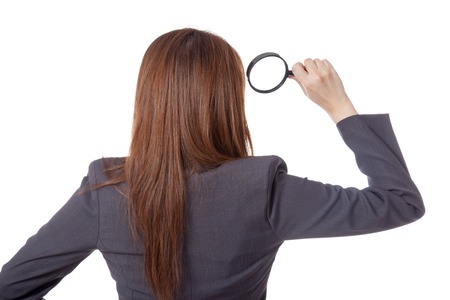 Back view of Asian businesswoman use magnifying glass isolated on white backgroundの写真素材