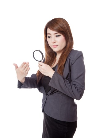 Asian businesswoman unhappy use magnifying glass watching hand isolated on white backgroundの写真素材