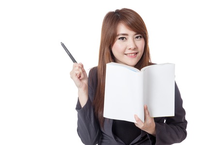 Asian businesswoman smile  read a book and point a pen to her right isolated on white backgroundの写真素材